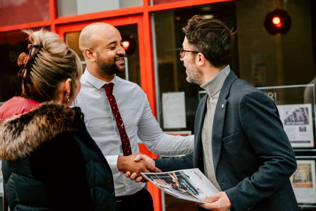 Estate agent talking to clients in front of the office