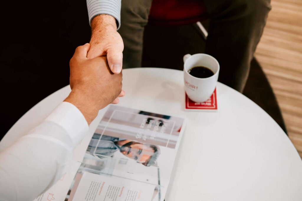 Buyer and seller shaking hands on an estate agency business sale